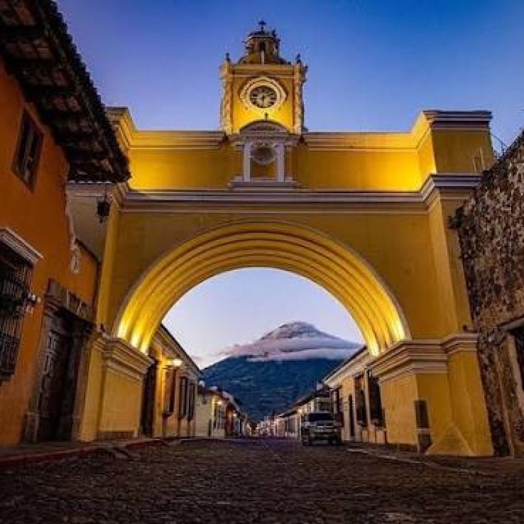 Arco de Santa Catalina en Antigua Guatemala con volcán de Fuego al fondo al atardecer