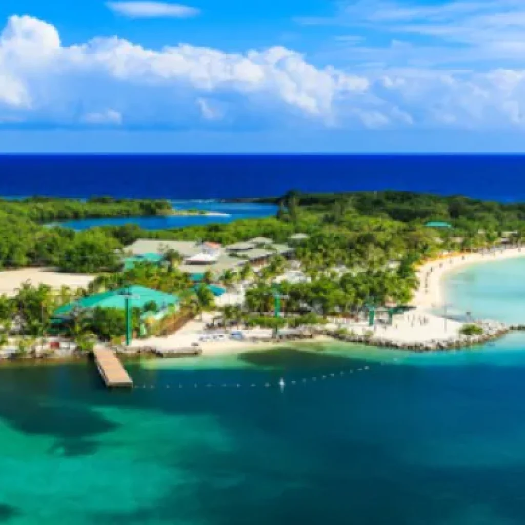 Playa de arena blanca con aguas cristalinas turquesas en isla Roatán Honduras